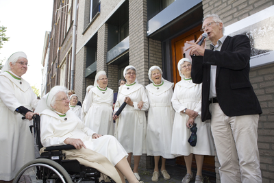 878097 Portret van de directeur van het Nederlands Volksbuurtmuseum (Waterstraat 27-29), Albert van Wersch, die een ...